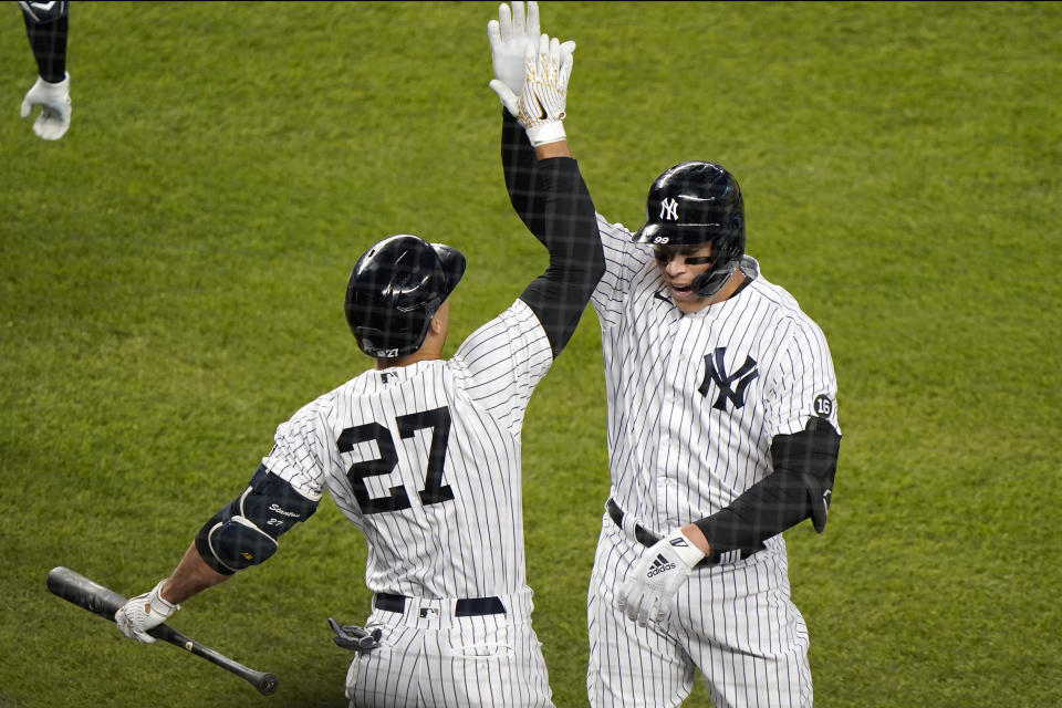 New York Yankees on-deck batter and designated hitter Giancarlo Stanton (27) celebrates with teammate Aaron Judge (99) after Judge hit a solo home run during the fourth inning of a baseball game against the Baltimore Orioles, Monday, April 5, 2021, at Yankee Stadium in New York. (AP Photo/Kathy Willens)