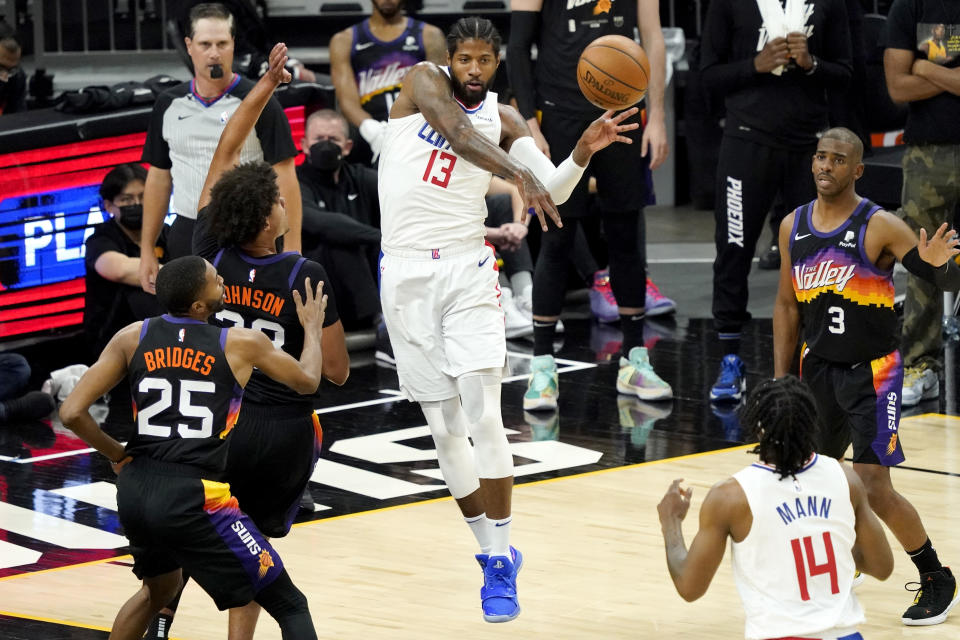 Los Angeles Clippers guard Paul George (13) passes as Phoenix Suns forward Cameron Johnson (23) looks on during the first half of game 5 of the NBA basketball Western Conference Finals, Monday, June 28, 2021, in Phoenix. (AP Photo/Matt York)