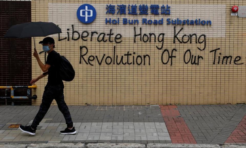 A demonstrator walks past graffiti as he marches during a protest in Hong Kong.