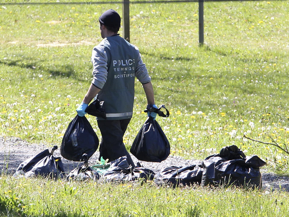 FILE - In this April 8, 2017 file photo, a French police officer collects plastic bags from a hideout used by Basque separatist guerrillas ETA in Saint Pee sur Nivelle, southwestern France. Josu Urrutikoetxea, the last known chief of ETA, the now-extinct Basque separatist militant group, goes on trial Monday Oct. 19, 2020 in Paris for terrorism charges that he deems “absurd” because of his role in ending a conflict that claimed hundreds of lives and terrorized Spain for half a century. (AP Photo/Bob Edme, File)