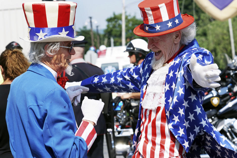 Uncle Sams Fred Polnisch and Gordon Dunham greet each other before the Fourth of July Parade, Thursday July 4, 2019, in the Pittsfield, Mass. (Ben Garver/The Berkshire Eagle via AP)