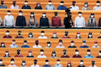A TV cameraman walks through the spectators' seating which are covered with pictures of fans, before the start of a regular season baseball game between Hanwha Eagles and SK Wyverns in Incheon, South Korea, Tuesday, May 5, 2020. South Korea's professional baseball league start its new season on May 5, initially without fans, following a postponement over the coronavirus. (AP Photo/Lee Jin-man)