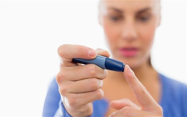 A woman tests her blood sugar levels  - Credit: Bill Cheyrou / Alamy