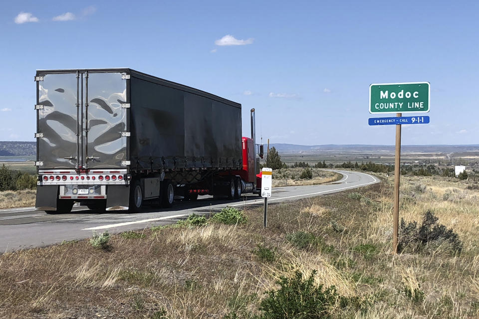 A northbound truck crosses the Modoc County line in Northern California along the high Sierra's eastern front, about 160 miles north of Reno, Nev., Friday, May 1, 2020, near Likely, Calif. For the first time in six weeks, there were diners in California restaurants. It happened in tiny Modoc County, hard against the Oregon border, which defied Gov. Gavin Newsom and reopened its economy, albeit with restrictions. (AP Photo/Scott Sonner)