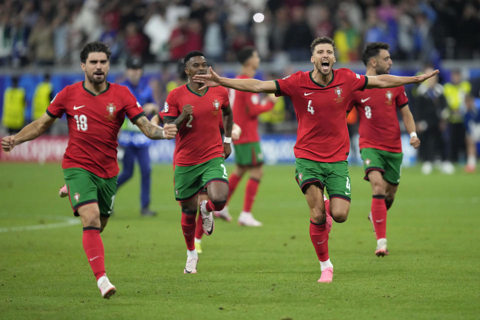 Portugal's players celebrate after winning the penalties shootouts of a round of sixteen match between Portugal and Slovenia at the Euro 2024 soccer tournament in Frankfurt, Germany, Monday, July 1, 2024. (AP Photo/Ariel Schalit)