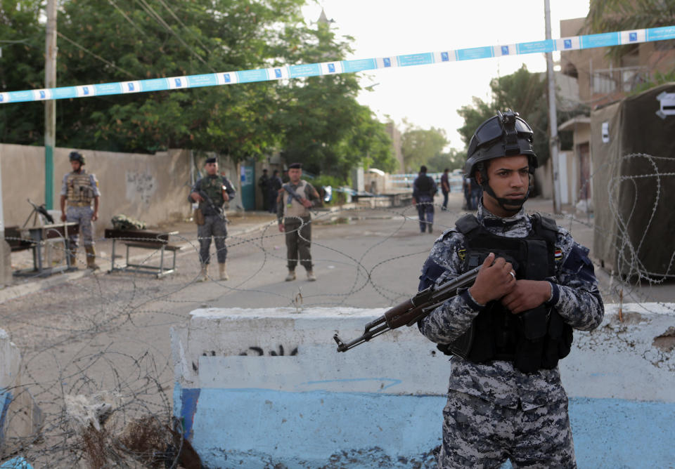 Security forces stand guard outside a polling center in Baghdad, Iraq, Monday, April 28, 2014. Amid tight security, some one million Iraqi army and police personnel have started voting for the nation's new parliament. (AP Photo/Khalid Mohammed)