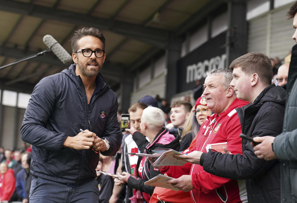 Wrexham co-owner Ryan Reynolds signs autographs ahead of the National League soccer match between Wrexham and Boreham Wood at The Racecourse Ground, in Wrexham, Wales, Saturday April 22, 2023. (Martin Rickett/PA via AP)