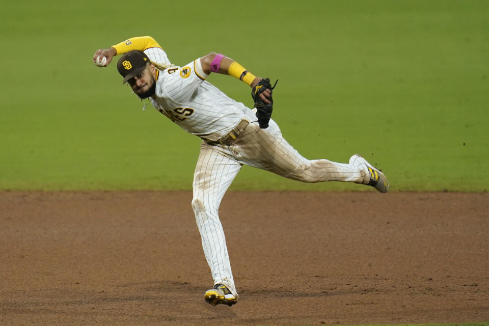 San Diego Padres shortstop Fernando Tatis Jr. throws to first too late as Los Angeles Angels' Luis Rengifo arrives safely for a single during the eighth inning of a baseball game Tuesday, Sept. 22, 2020, in San Diego. (AP Photo/Gregory Bull)