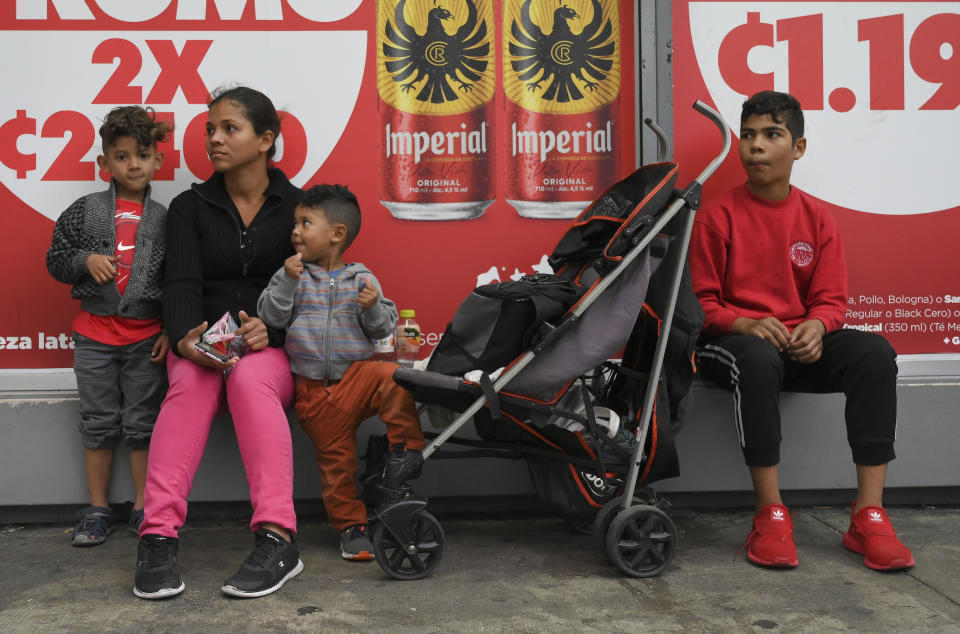 Venezuelan migrants Marielis Marqués, together with her children, sell sweets on a street in San Jose, Costra Rica, Tuesday, Dec. 6, 2022. Faced with an overwhelmed asylum system, Costa Rica, one of the world’s great refuges for those fleeing persecution, is tightening its generous policies after President Rodrigo Chaves said the country’s system is being abused by economic migrants. (AP Photo/Carlos Gonzalez)