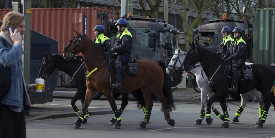 Police, front, and army trucks, rear, block the roads leading to parliament during a farmers demonstration in The Hague, Netherlands, Wednesday, Feb. 19, 2020. Dutch farmers, some driving tractors, poured into The Hague on Wednesday to protest government moves to rein in carbon and nitrogen emissions to better fight climate change. (AP Photo/Peter Dejong)