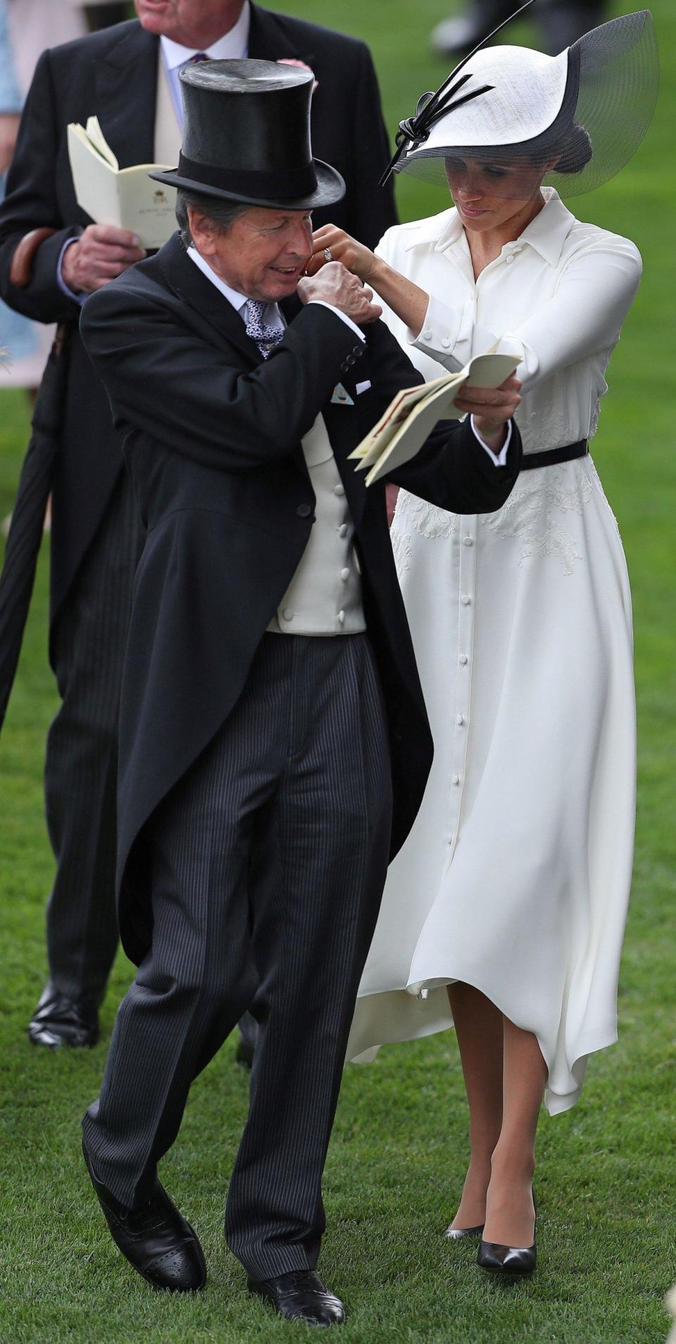 The Duchess helps the Queen's Bloodstock and Racing Advisor, John Warren, as his binoculars slipped off of his shoulder (AFP/Getty Images)