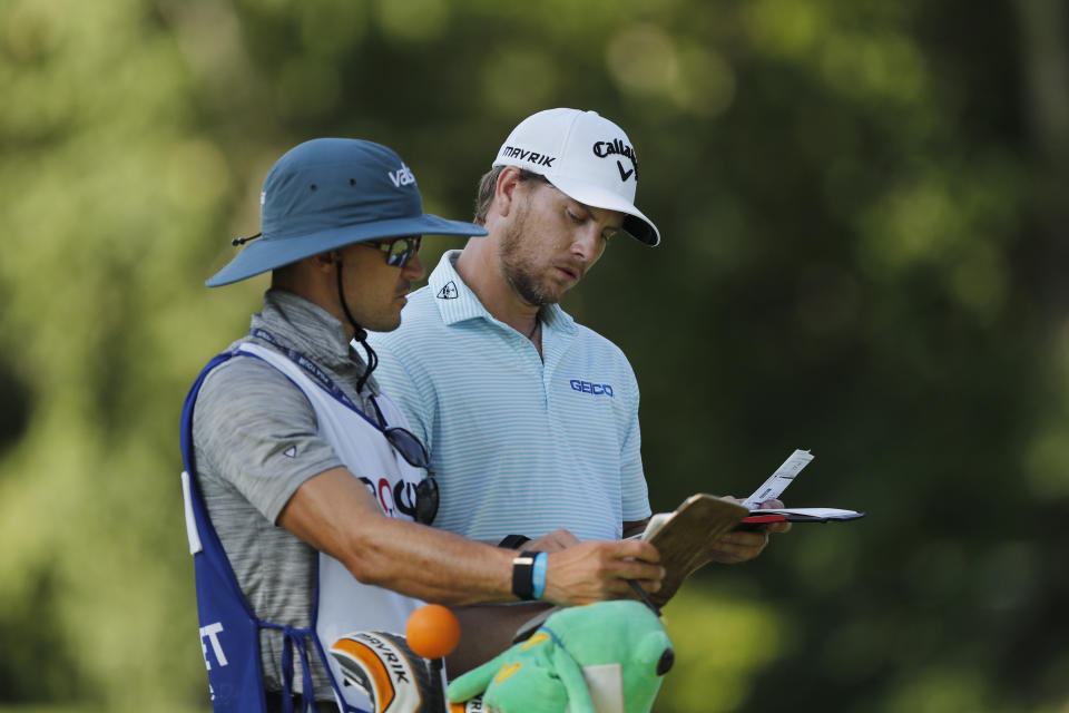 Chris Stroud checks the yardage with his caddie on the ninth tee during the first round of the Rocket Mortgage Classic golf tournament, Thursday, July 2, 2020, at Detroit Golf Club in Detroit. (AP Photo/Carlos Osorio)