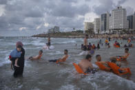 Palestinians enjoy the day on the beach during the Eid Al Adha festival in Tel Aviv, Israel, Wednesday, July 21, 2021. The major Muslim holiday, at the end of the hajj pilgrimage to Mecca, is observed around the world by believers and commemorates prophet Abraham's pledge to sacrifice his son as an act of obedience to God. (AP Photo/Oded Balilty)