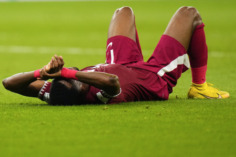 Qatar's Ismail Mohamad lies after his side's 1-3 lost against Senegal during a World Cup group A soccer match at the Al Thumama Stadium in Doha, Qatar, Friday, Nov. 25, 2022. (AP Photo/Petr Josek)