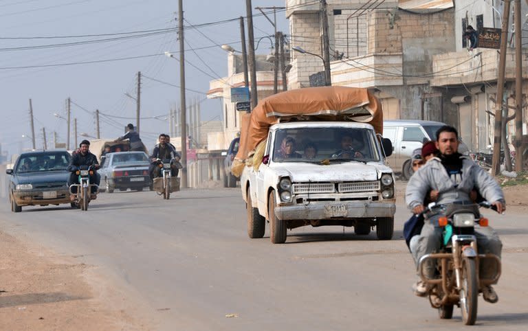 Syrian residents drive motorcycles and cars to flee during fighting between rebels and regime forces in the village of Kurnaz, close to the western city of Hama, on January 27, 2013. The Syrian opposition appealed Monday for hundreds of millions of dollars (euros) to step up the revolt against Bashar al-Assad, as the president asserted his forces had made "significant gains" in the conflict