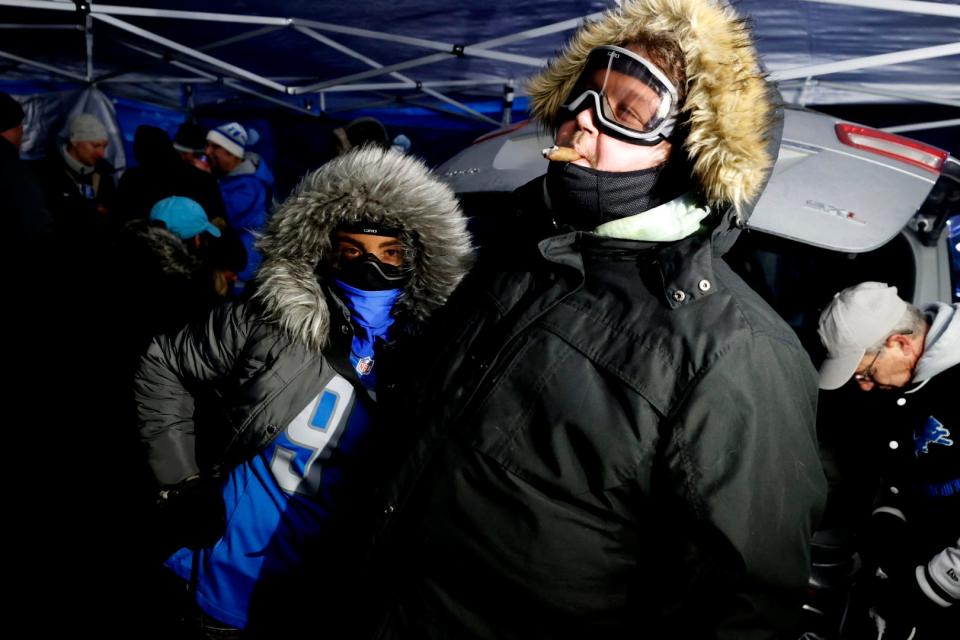 (L to R) Friends Robin Bliss, 29, and John Lowman, 33, both of Detroit, came dressed for the cold weather while tailgating outside of Comerica Park before the Detroit Lions first playoff game at Ford Field against the L.A. Rams in Detroit on Sunday, January 14, 2024.