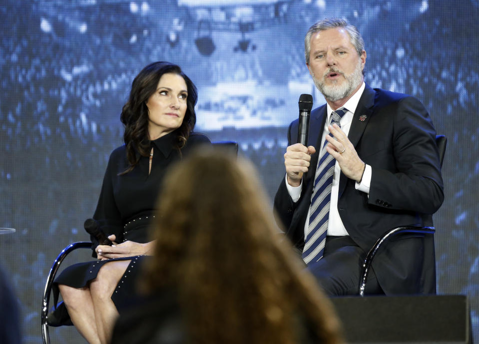 FILE - In this Wednesday, Nov. 28, 2018 file photo, Jerry Falwell Jr., right, answers a student's question, accompanied by his wife, Becki, during a town hall meeting on the opioid crisis at a convocation at Liberty University in Lynchburg, Va. On Aug. 7, 2020, Falwell stepped down, at least temporarily, from his role as the president of the school. (AP Photo/Steve Helber)