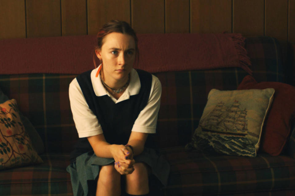 Christina sitting on a couch in her school uniform on "Lady Bird"