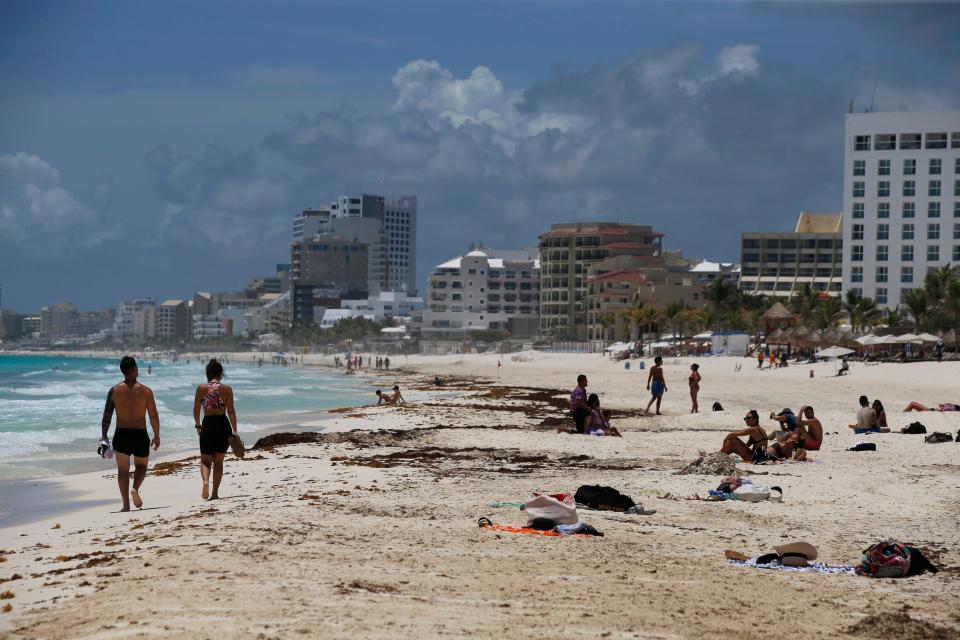 Tourists enjoy the beach in Cancun, Quintana Roo State, Mexico, Wednesday, Aug. 18, 2021.