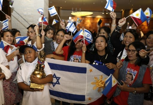 Filipinos wave their flag and the Israeli one as they wait for Philippine President Rodrigo Duterte to arrive in Israel for an official visit, on September 2, 2018