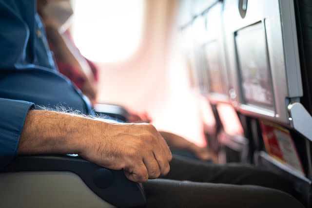 <p>Getty</p> Aisle seat passenger using aisle armrest