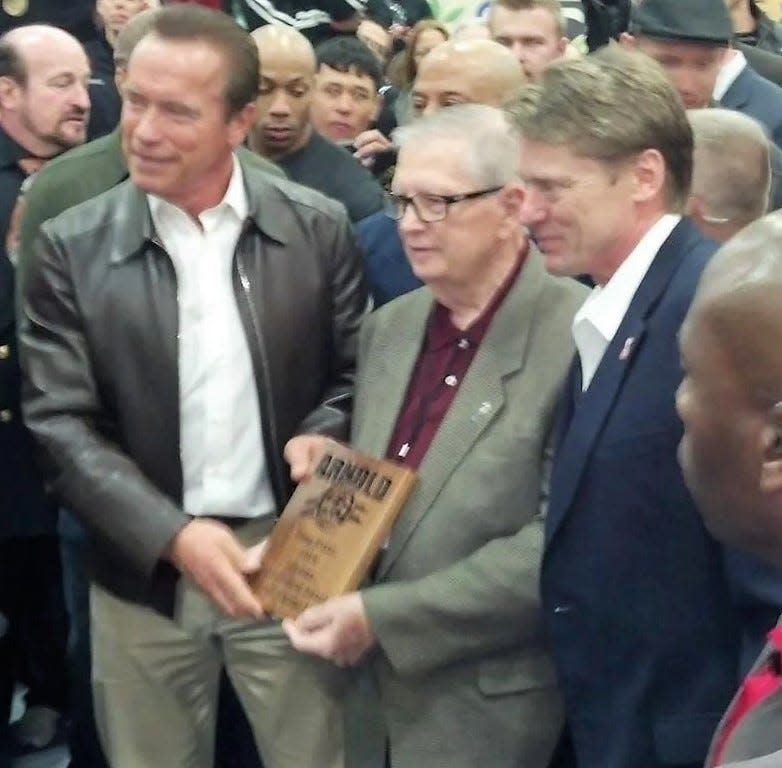 Arnold Schwarzenegger and Tokey Hill present Coshocton native Doug Grant, center, with a lifetime achievement award for his contributions to martial arts and the Arnold Sports Festival in 2014. Grant died May 9 in Hilliard.