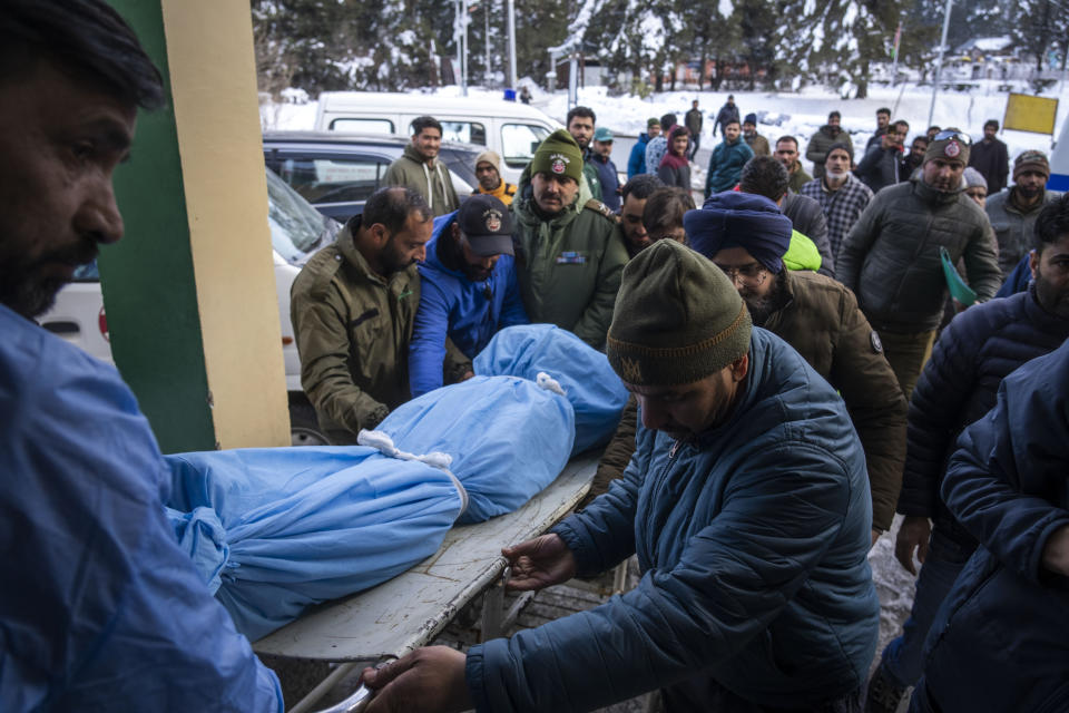 Volunteers bring the body of a Russian skier into a hospital in Tangmarg, near Gulmarg, a popular skiing destination in Indian controlled Kashmir, Thursday, Feb. 22, 2024. Officials say that the Russian skier was killed by an avalanche that hit Gulmarg on Thursday. (AP Photo/Dar Yasin)