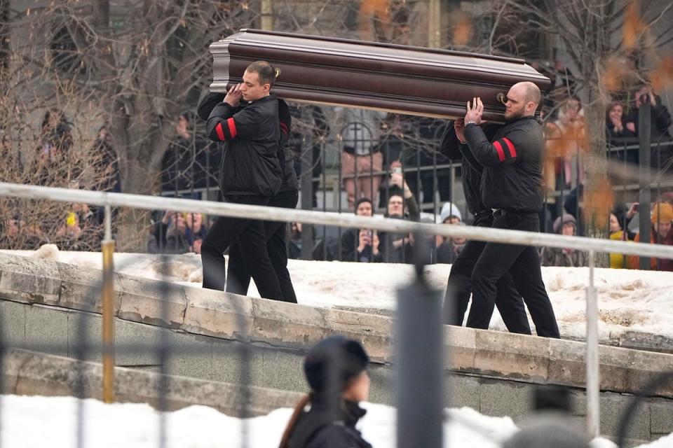 Workers carry the coffin of Alexei Navalny into the church (AP)