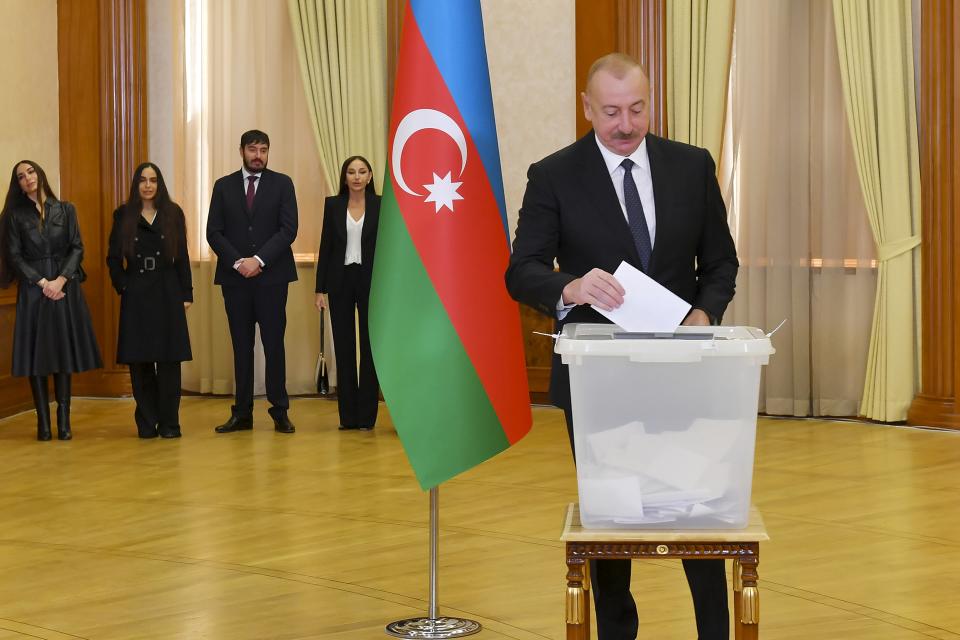 Azerbaijan President Ilham Aliyev casts his ballot as his family members stand near during presidential election at a polling station in Khankendi, Karabakh region, Azerbaijan, Wednesday, Feb. 7, 2024. Azerbaijanis are voting Wednesday in an election almost certain to see incumbent President Ilham Aliyev chosen to serve another seven-year term. (Vugar Amrullaev/Azerbaijan State News Agency AZERTAC via AP)