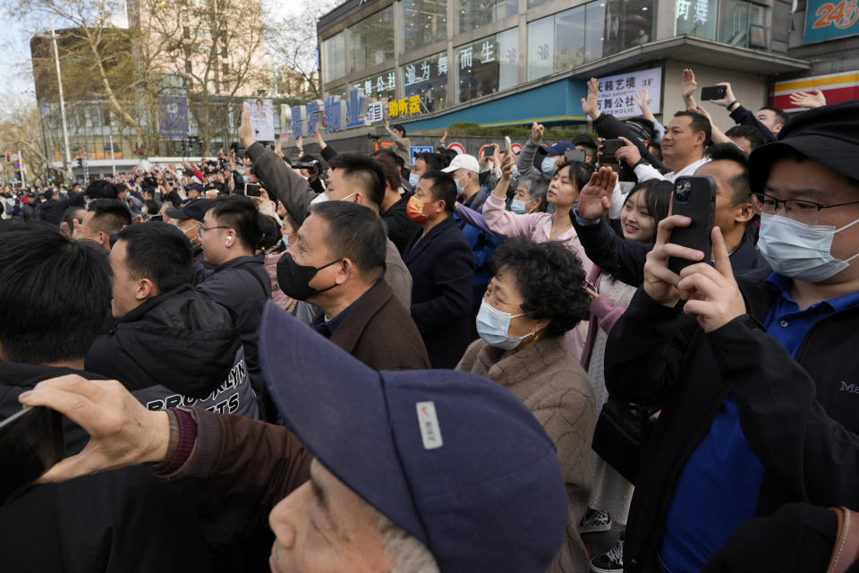 Residents wave as former Taiwan President Ma Ying-jeou leaves from the John Rabe Former Residence during his visit in Nanjing, in eastern China's Jiangsu province, Tuesday, March 28, 2023. Former Taiwan President Ma Ying-jeou began a 12-day tour of China with a symbolism-laden visit to the mausoleum where the founding father of both China and Taiwan is entombed. (AP Photo/Ng Han Guan)