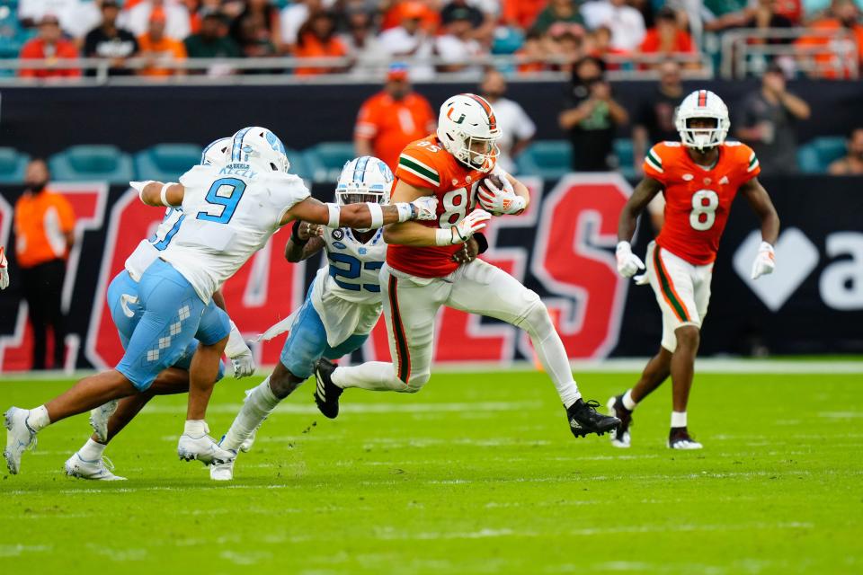 Oct 8, 2022; Miami Gardens, Florida, USA;North Carolina Tar Heels defensive back Cam'Ron Kelly (9) tackles Miami Hurricanes tight end Will Mallory (85) during the first half at Hard Rock Stadium. Mandatory Credit: Rich Storry-USA TODAY Sports