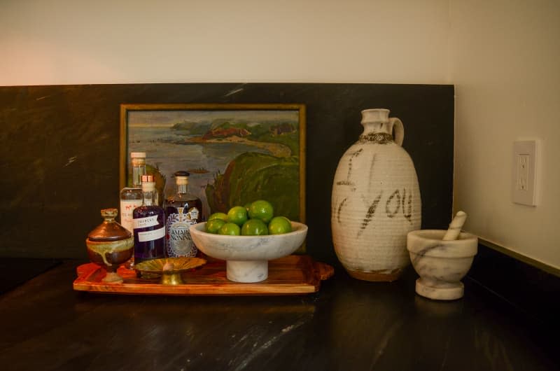 Accessorized corner of kitchen with dark countertop.