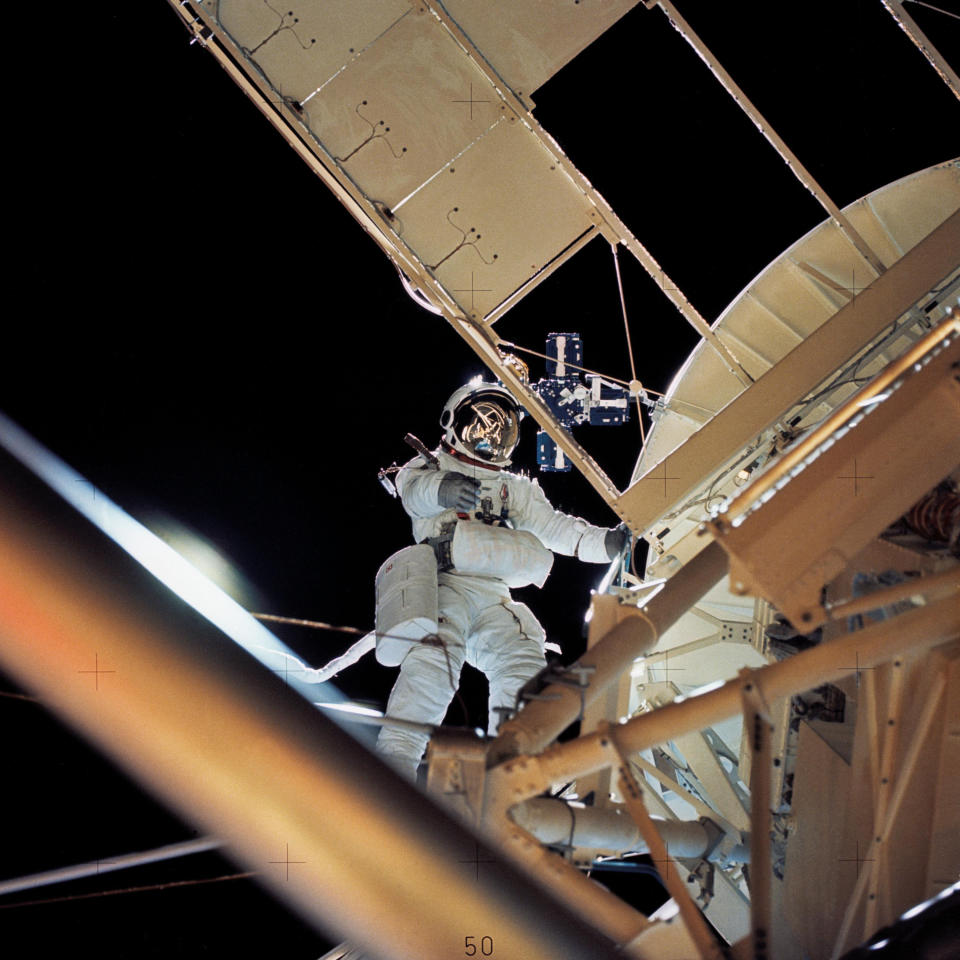 In this August 1973 photo made available by NASA, astronaut Owen K. Garriott retrieves an imagery experiment from the Apollo Telescope Mount attached to the Skylab in Earth orbit. The space agency said Garriott died at his home in Huntsville, Ala., on Monday, April 15. 2019. He was 88. (NASA via AP)