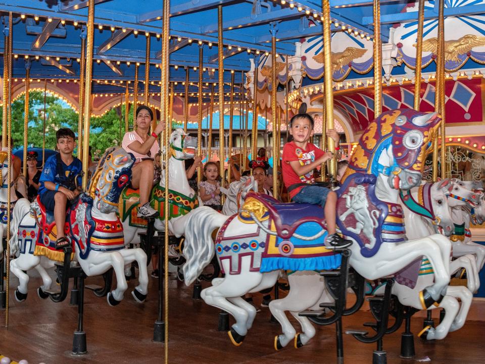 children riding the carousel ride at disney world