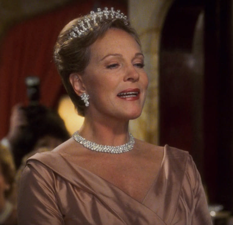 the queen wears a diamond necklace, earrings, and tiara