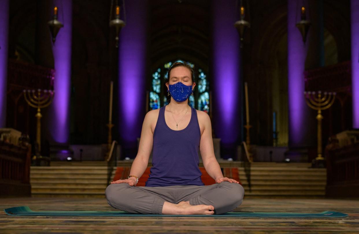 Mia Michelson-Bartlett practices yoga and mindfulness meditation virtually from inside Saint John the Divine on March 25, 2021 in New York City. (Photo by Angela Weiss / AFP)