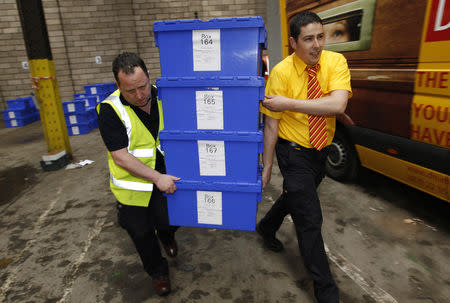 FILE PHOTO: Edinburgh City Council contractors carry boxes of postal ballots in a storage warehouse in Edinburgh, Scotland May 5, 2010. REUTERS/David Moir/File Photo