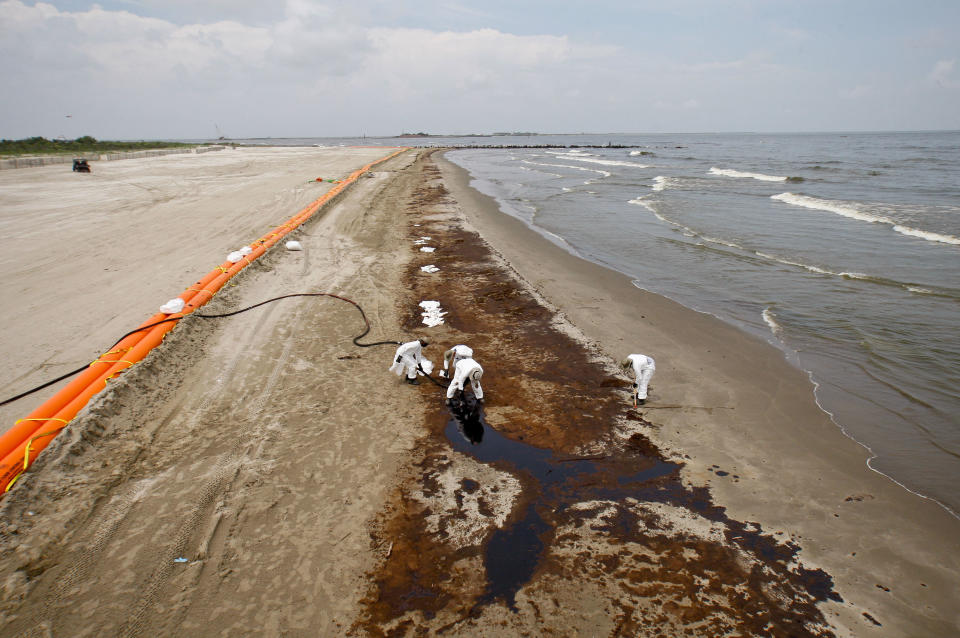 BP&nbsp;oil company contract workers remove oil that washed onto the beach at Grand Isle State Park in Louisiana on June 6, 2010. (Photo: Bloomberg via Getty Images)