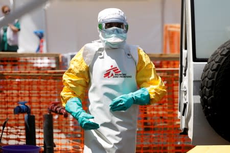 FILE PHOTO: A health worker dressed in protective suit disinfects an ambulance transporting a suspected Ebola patient to the newly constructed MSF Ebola treatment centre in Goma