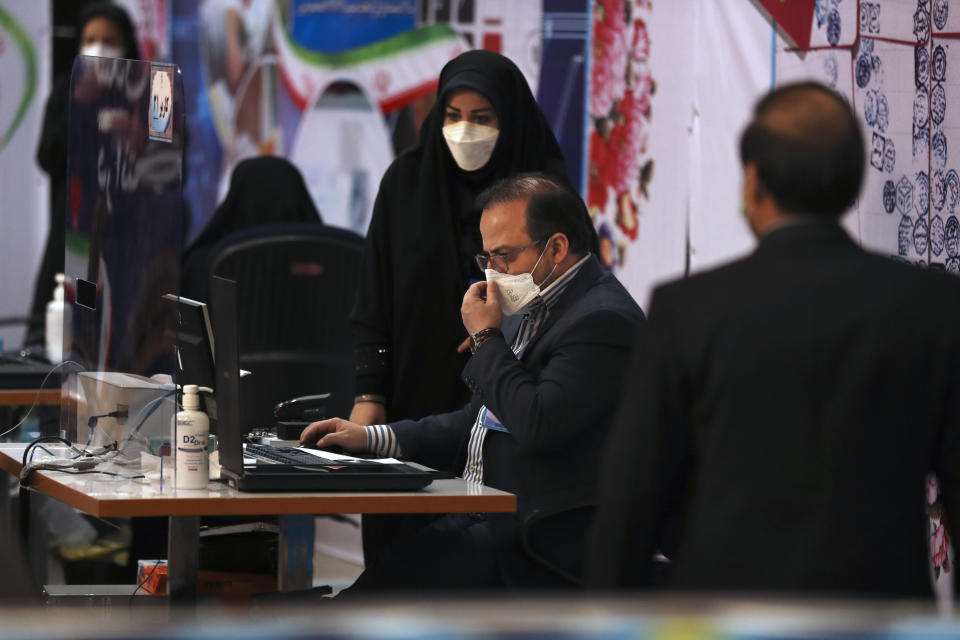 Elections headquarters staff work to register candidates for the June 18 presidential elections at the Interior Ministry in Tehran, Iran, Tuesday, May 11, 2021. Iran opened registration Tuesday for potential candidates in the country's June presidential election, kicking off the race as uncertainty looms over Tehran's tattered nuclear deal with world powers and tensions remain high with the West. (AP Photo/Vahid Salemi)