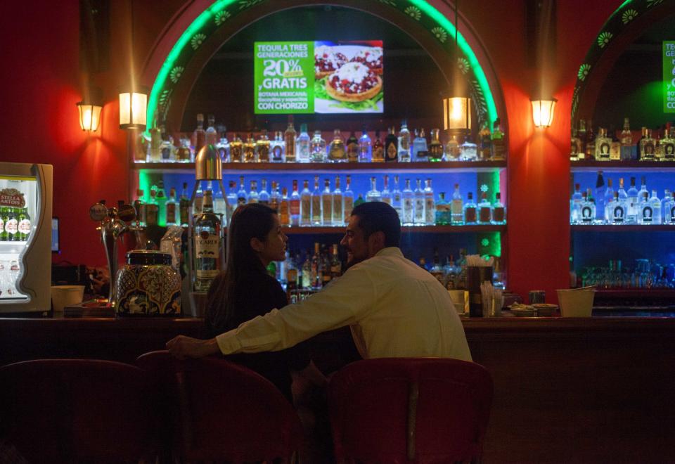 FILE - In this Aug. 21, 2015 file photo, a couple sits in the upstairs bar at the Tenampa cantina at the Garibaldi Plaza, in Mexico City. At the Tenampa cantina, which bills itself as having first brought mariachi troupes to the plaza in the 1920s, a manager said it was business as usual Saturday, Sept. 15, 2018, despite a brazen Friday night shooting that killed four people and wounded nine in Garibaldi Plaza. (AP Photo/Sofia Jaramillo, File)