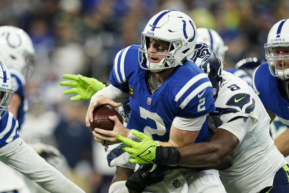 Indianapolis Colts quarterback Carson Wentz (2) is sacked by Seattle Seahawks defensive end Carlos Dunlap (8) in the first half of an NFL football game in Indianapolis, Sunday, Sept. 12, 2021. (AP Photo/Charlie Neibergall)
