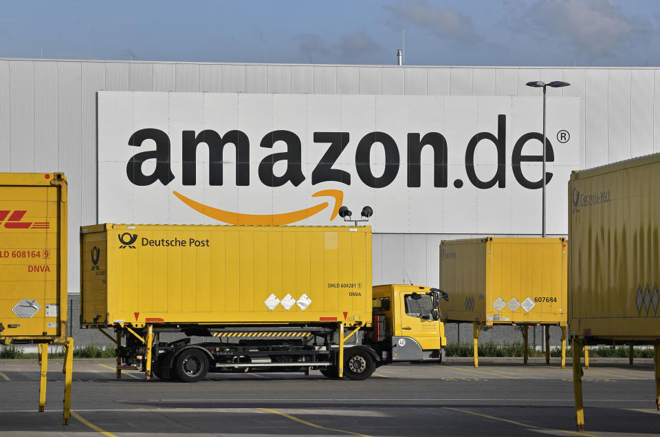 FILE - In this file photo dated Wednesday, Nov. 14, 2018, post trucks leaves the Amazon Logistic Center in Rheinberg, Germany. Germany's antitrust agency said Thursday Nov. 29, 2018, it has begun an investigation into online retailer Amazon over complaints that it's abusing its dominant position to the detriment of other sellers using its platform. (AP Photo/Martin Meissner, FILE)