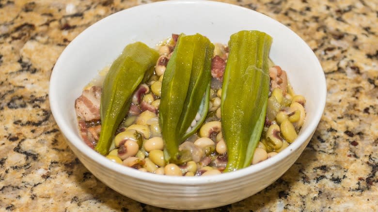 Cooked purple hull peas served in a bowl with bacon and okra