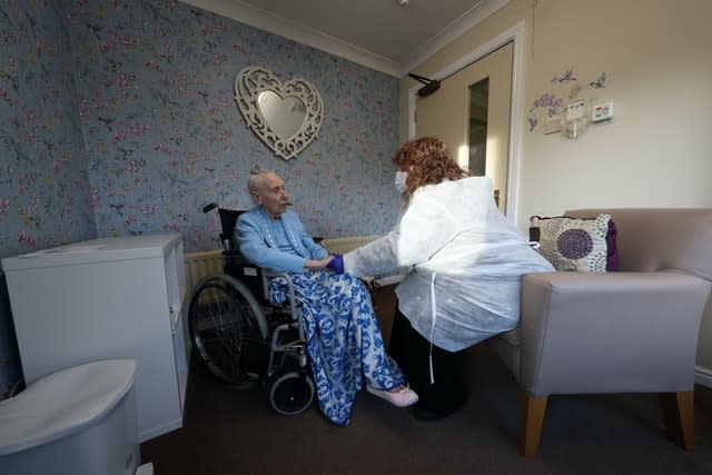 Woman sat with her friend during a Christmas Day visit at a care home