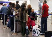 FILE PHOTO: People wait in line to check in at the Spirit Airlines counter at LaGuardia Airport in New York