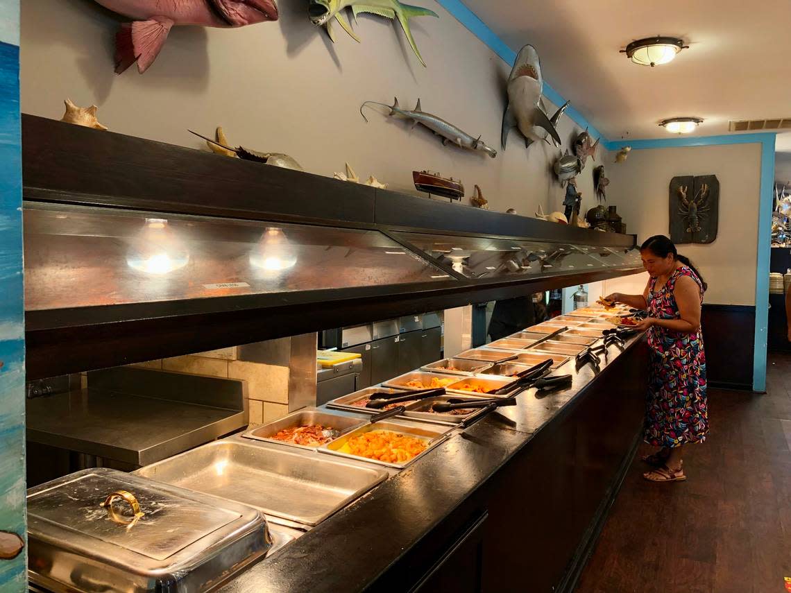 A diner fills her plate at the fried fish section of Captain Benjamin’s Calabash Seafood Buffet in Myrtle Beach, SC. Calabash-style fried fish can be found in North and South Carolina and beyond. July 28, 2023.