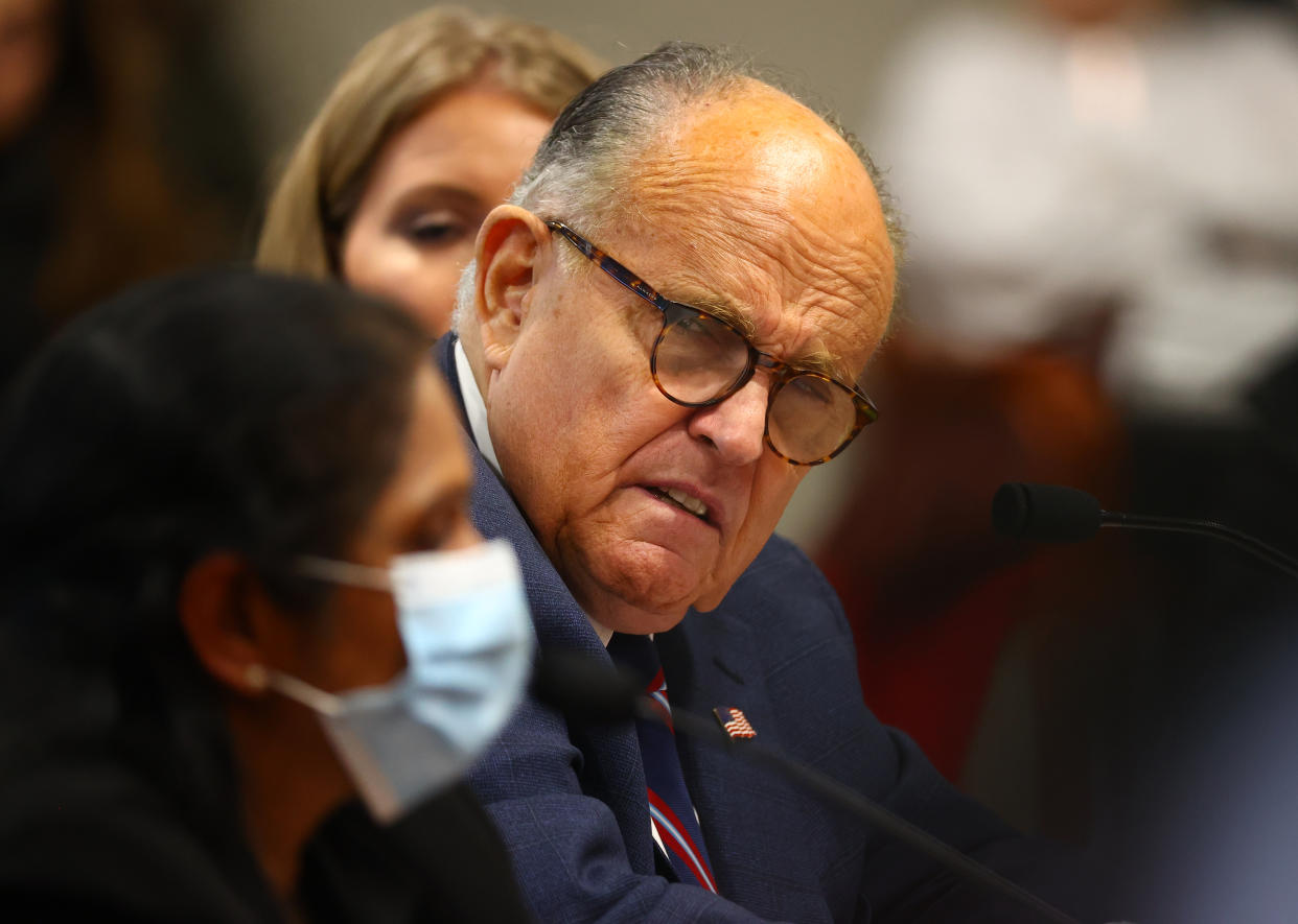 Rudy Giuliani listens to a Detroit poll worker during an appearance before the Michigan House Oversight Committee on Dec. 2 in Lansing. (Rey Del Rio/Getty Images)