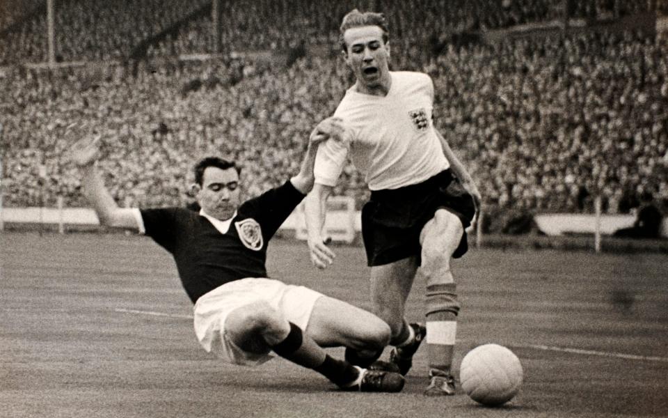 Holden is tackled by Duncan MacKay during England's 1-0 win against Scotland at Wembley in April 1959 - Popperfoto via Getty Images