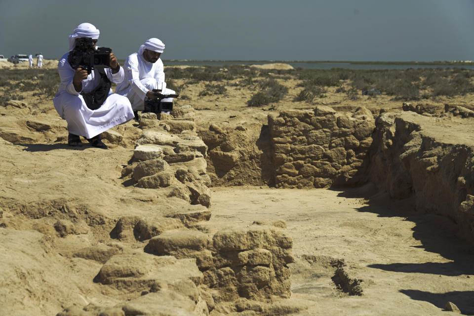 Journalists film uncovered ruins on Siniyah Island in Umm al-Quwain, United Arab Emirates, Monday, March 20, 2023. Archaeologists said Monday they have found the oldest pearling town in the Persian Gulf on an island off one of the northern sheikhdoms of the United Arab Emirates. (AP Photo/Jon Gambrell)